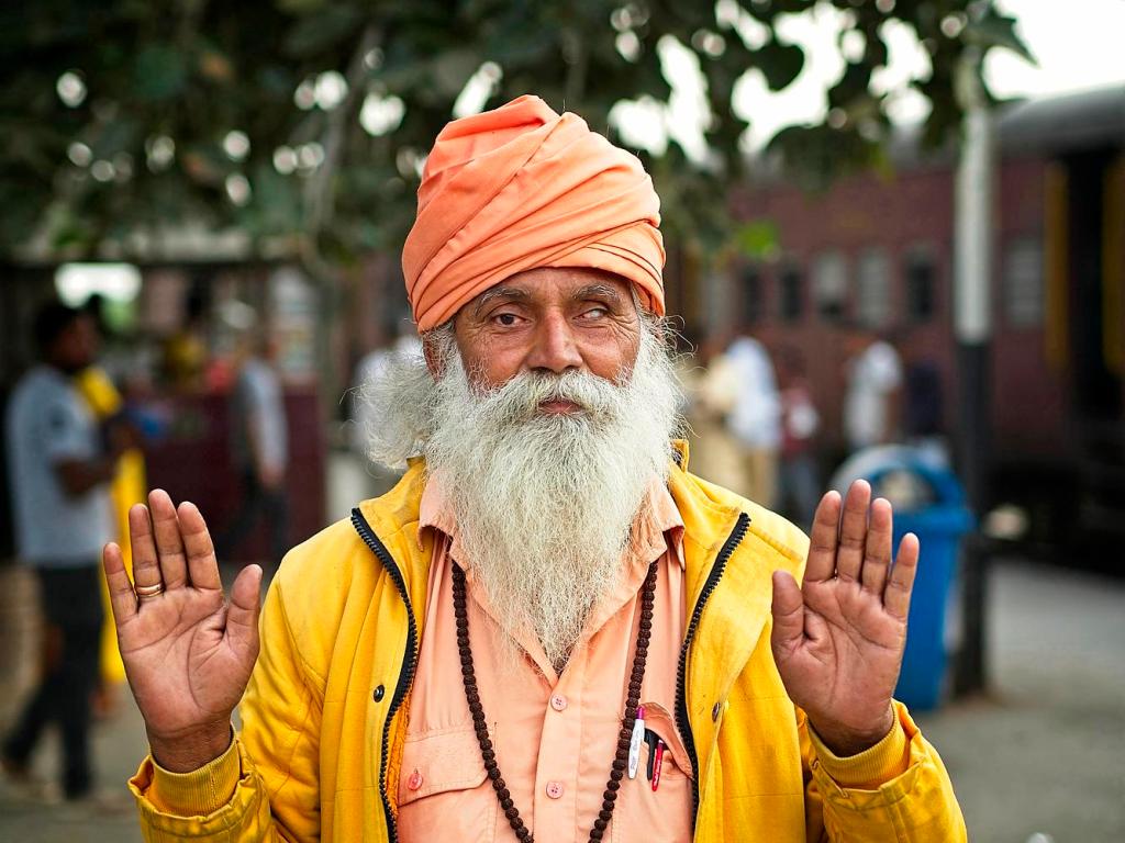 Indian Man with hands up in Turban at Train Station, Rajasthan, India by Sam Davis Photographer